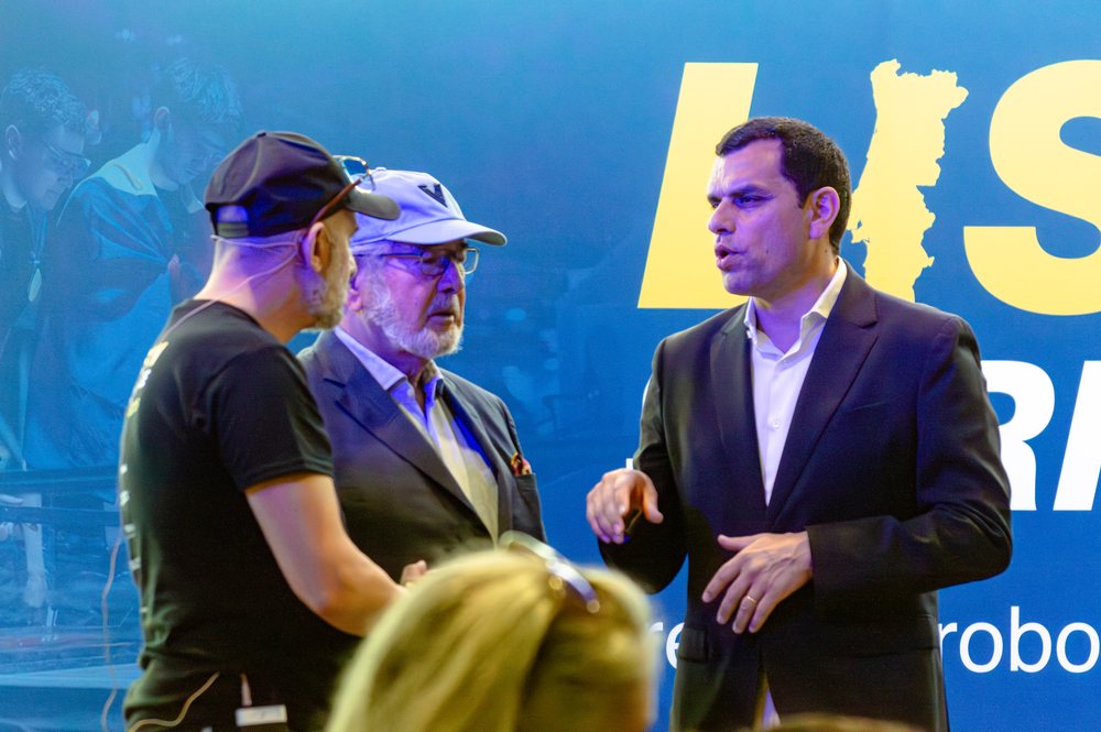 Guests in conversation beside the event backdrop